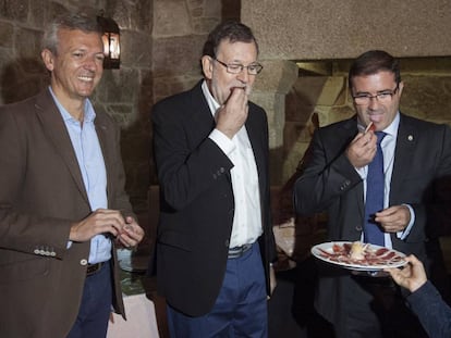 Mariano Rajoy; el vicepresidente de la Xunta, Alfonso Rueda, y el alcalde de A Cañiza (Pontevedra), Miguel Domínguez, degustan una tapa de jamón.