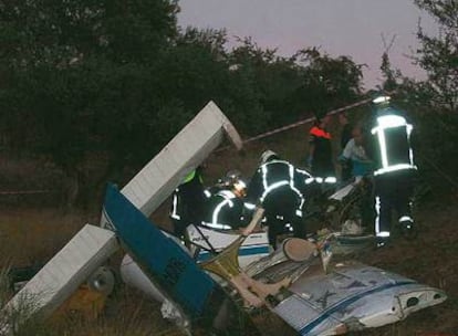 Bomberos de la Comunidad de Madrid extraen el cadáver de uno de los fallecidos en el accidente de la avioneta.