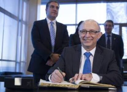 El ministro de Hacienda, Cristobal Montoro firma en el libro de autoridades durante su visita a la Diputacin de Mlaga.