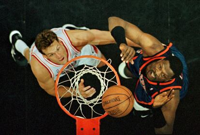 Ewing (d) salta por el balón ante Dan Majerle de los Miami Heat en un partido contra los Knicks en 1999.