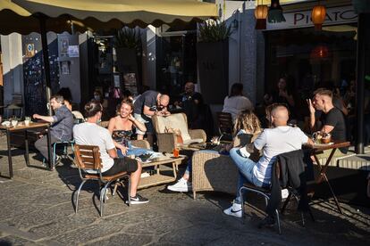 People sit in a restaurant's outdoor seating area in Milan, Italy, on Wednesday.