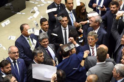 Outro momento teatral da sessão foi quando deputados da oposição atiraram para o alto notas falsas de dólares e reais com imagens de Temer. 