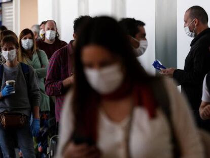 Un grupo de viajeros este domingo, en el aeropuerto de Santiago de Chile, espera embarcar en un vuelo de repatriación a España.