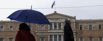  Varias personas pasan delante del Parlamento Griego en Atenas