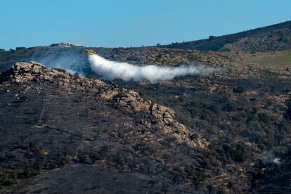 Un hidroavión lanza agua encima de un pequeño foco que ha reavivado en el área afectada por del incendio de Puig Rodó, Puig Alt i Puig Trencat entre Cala Murtra y Cala Montjoi en Roses, Costa Brava (Girona).