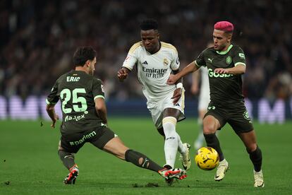 Vinicius, entre Yan Couto y Eric García, durante el partido entre el Real Madrid y el Girona.