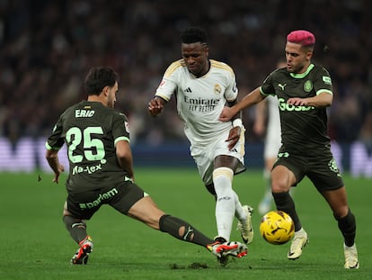 Vinicius, entre Yan Couto y Eric García, durante el partido entre el Real Madrid y el Girona.