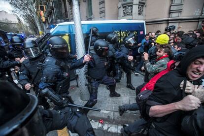 Miembros de los Mossos d´Esquadra impiden el paso de manifestantes en las inmediaciones de la Delegación del Gobierno en Cataluña, donde centenares de independentistas tratan de desbordar el cordón policial en protesta por la detención del expresidente catalán Carles Puigdemont. 