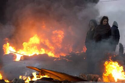 Refugiados israelíes queman llantas a la entrada de un asilo ilegal antes del inicio del desalojo en Amoná (Cisjordania).