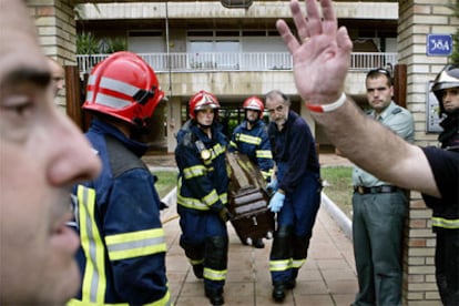 Los bomberos sacan el cuerpo de una de las víctimas.