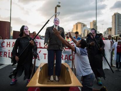 Um boneco de Geraldo Alckmin toma banho durante protesto.