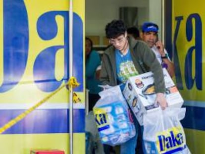 Un hombre sale con algunas compras de electrodomésticos en una de las sedes de la cadena de tiendas Daka este lunes 11 de noviembre del 2013, en Caracas (Venezuela).