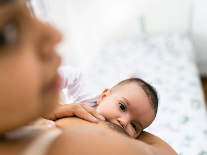 Una mujer da de mamar a su bebé.