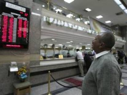 Un hombre revisa un panel con el valor alcanzado por varias divisas en un banco de El Cairo (Egipto). EFE/Archivo