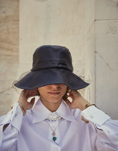 Sombrero de Dior; pendientes Essential V, de Louis Vuitton; collar de Dior y colgante de corazón de Suarez. En la muñeca derecha, reloj Datejust, de Rolex; en la izquierda, pulseras de Celine. Camisa y gemelos, todo de Gucci.