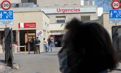 Una mujer protegida con mascarilla pasea cerca de la puerta de Urgencias del Hospital Gregorio Marañón, este sábado.