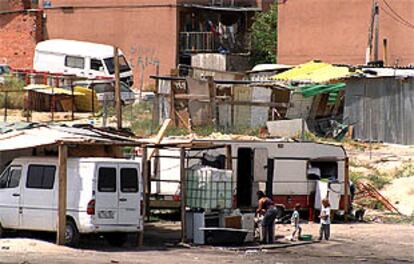 Habitantes del poblado chabolista de Las Mimbreras, en Latina, frente a uno de los chamizos, horas después del tiroteo mortal.