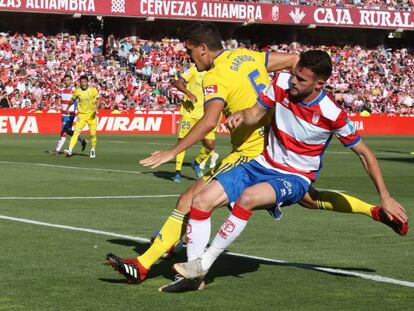 Garrido pelea el balón con Quini. 