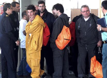 Agentes de salvamento, con parte de la tripulación del <i>Shark</i>, a su llegada al aeropuerto coruñés de Alvedro.