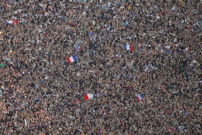 Aficionados franceses agitando banderas de su país, asisten a un concierto en la fan zone de fútbol cerca de la Torre Eiffel, como parte de la próxima Eurocopa 2016.