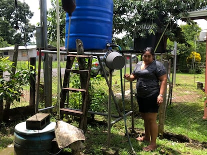 Una mujer junto a un tambo donde almacena agua en el caserío rural Los Lirios de Sarapiquí, Costa Rica.