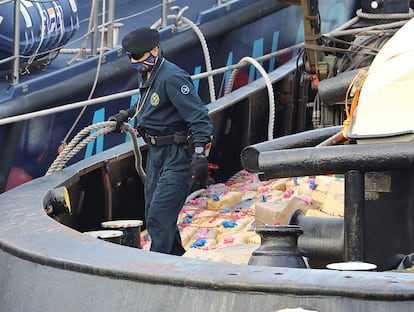 Un agente de Vigilancia Aduanera, en la cubierta del barco junto a parte del alijo de hachís intervenido.