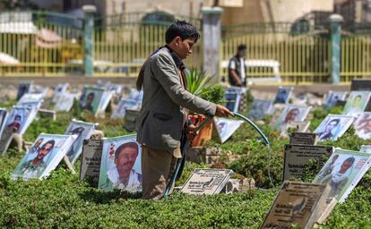 Un joven yemení riega las plantas de un cementerio en Saná (Yemen).