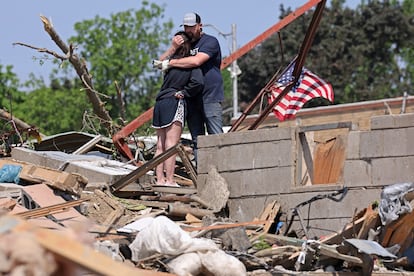 Phillip y Kimberly Ergish se abrazan mientras miran los restos de su casa destruída, en Greenfield, Iowa. Las tormentas y tornados dejaron un saldo de por lo menos 21 muertos durante el pasado fin de semana.