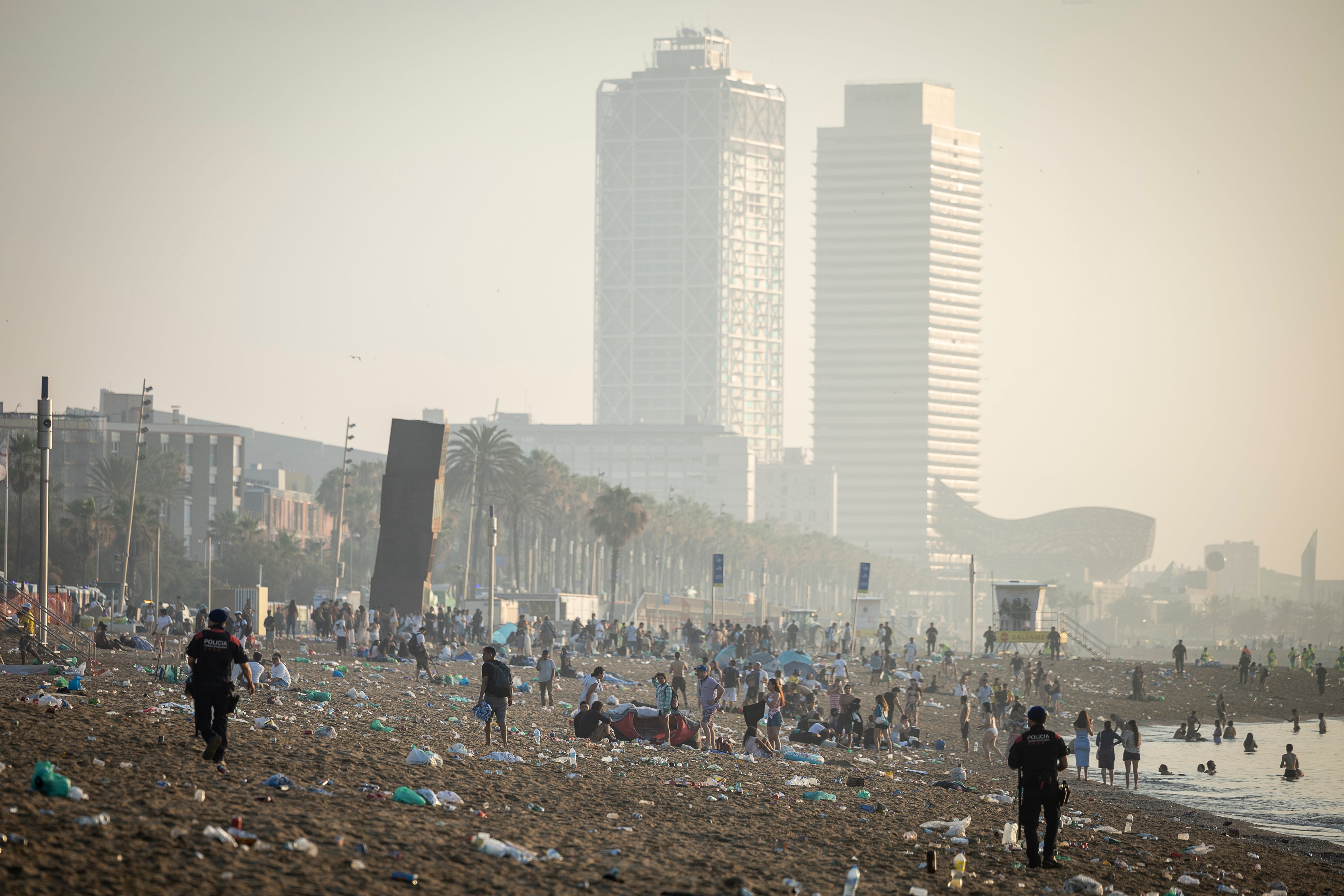 Los Mossos d'Esquadra desalojan la playa de la Barceloneta.