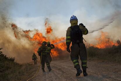 Los bomberos trabajan en la parroquia de Vilela en Cualedro a mediodía del sábado, al poco de declararse el incendio.