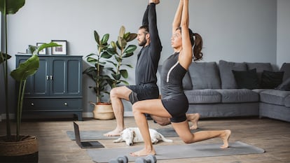 Una pareja haciendo deporte en casa.