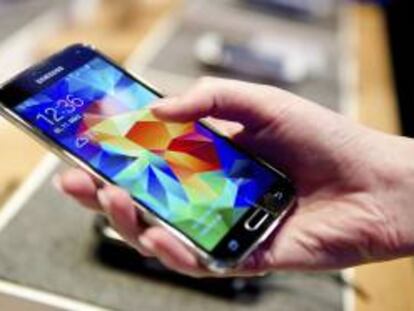 Una mujer sostiene en su mano un teléfono inteligente Samsung Galaxy S5. EFE/Archivo