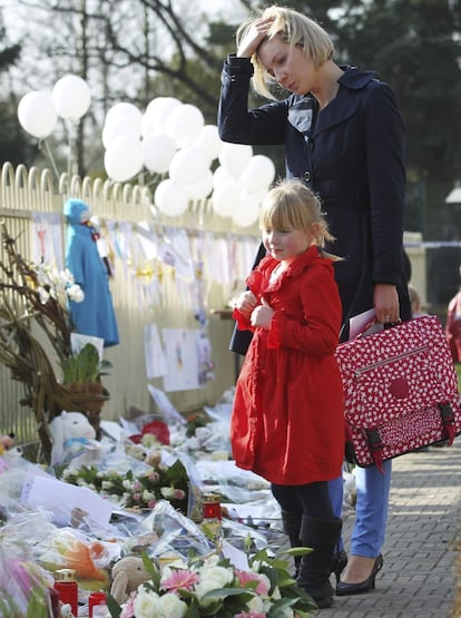 Una madre y una hija observan en el exterior del ayuntamiento de la localidad belga de Lommel flores y velas en memoria de los niños muertos en el accidente de autocar registrado el martes en Suiza, hoy, jueves 15 de marzo de 2012. En el accidente fallecieron 22 niños y 6 adultos. Los menores estudiaban en escuelas de Lommel y Heverlee (Bélgica).