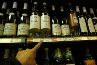 Un hombre señala varios vinos españoles que se ofrecen en el único supermercado de Puerto Stanley (Malvinas).