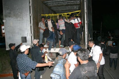 Inmigrantes interceptados por las autoridades mexicanas bajan de uno de los dos camiones que los transportaba a Estados Unidos.