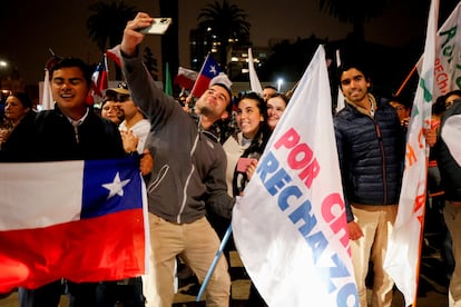 Inicia ahora una nueva etapa, con un Ejecutivo obligado a mantener vivo el proceso constituyente pero muy debilitado para imponer sus ideas y hasta la hoja de ruta. En la imagen, una pareja se fotografía mientras celebran el rechazo a la nueva Constitución en Santiago.