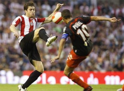 El jugador del Athletic Club de Bilbao Iñaki Muñoz disputa un balón con el centrocamipsta del Club Atlético Osasuna, Patxi Puñal