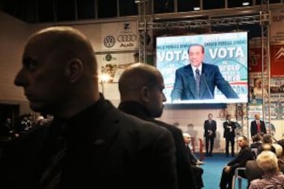 En la pantalla, Silvio Berlusconi durante un acto electoral.