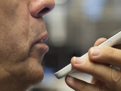 Un hombre usando el asistente virtual Siri.