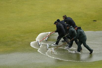 El juego tuvo que ser suspendido por la lluvia en la segunda ronda del Open de golf Old Course, en St. Andrews. En la imagen, unos operarios trabajan en las labores de secado del campo.