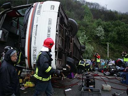 Varios miembros de los equipos de rescate trabajan en torno al autobús siniestrado ayer en Villallana (Asturias).
