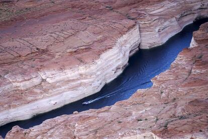 Una lancha recorre un cañón del lago Powell, una reserva artificial creada en 1963 en el río Colorado gracias a la construcción de la presa del cañón Glen.