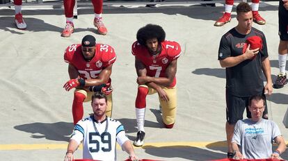 Colin Kaepernick y uno de sus compa&ntilde;eros se arrodillan ante el himno en se&ntilde;al de protesta.