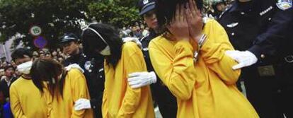 La Policía vigila a las prostitutas durante el desfile público en la ciudad de Shenzhen (sur de China).