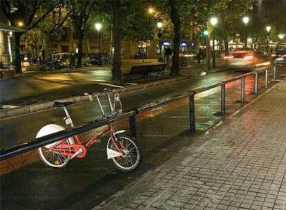 Una bicicleta, con una rueda pinchada, en la estación de la Rambla Catalunya con Consell de Cent el lunes por la noche.
