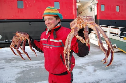 Un pescador ofrece dos ejemplares de cangrejo rojo real, en Noruega.