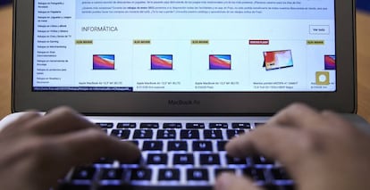 Una persona utiliza un ordenador para comprar online.