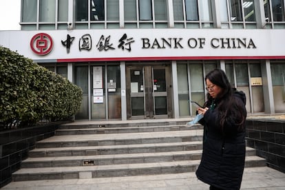 Una mujer camina junto a una sucursal bancaria en China.