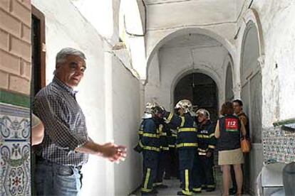 Vecinos, bomberos y servicios sanitarios, ayer, en la entrada del edificio siniestrado.