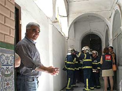 Vecinos, bomberos y servicios sanitarios, ayer, en la entrada del edificio siniestrado.